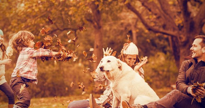 Young family with a dog in leaves on an autumns day