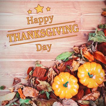 Happy thanksgiving against overhead view of pumpkins surrounded by leaves on table