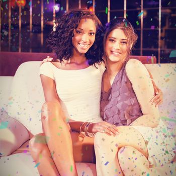 Pretty girls sitting on a couch against flying colours