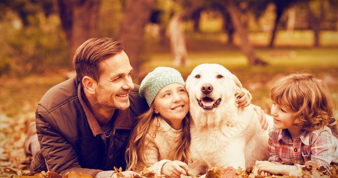 Smiling young family with dog on an autumns day