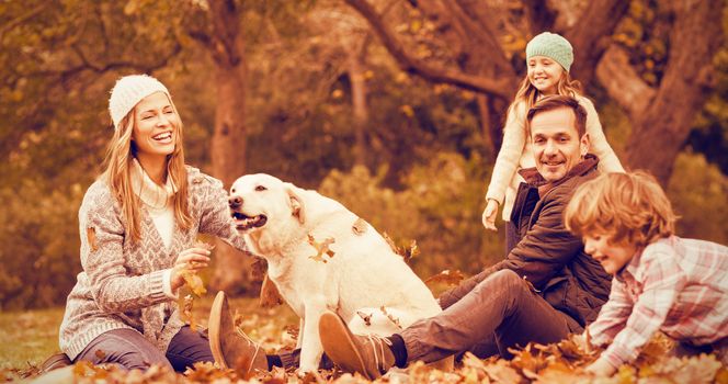 Young family with a dog in leaves on an autumns day