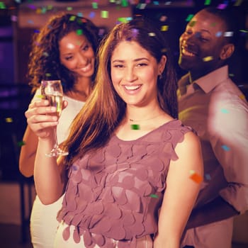 Group of young friends having fun while holding drink against flying colours