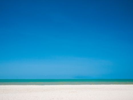 White sand beach with clear bright blue sky over sea