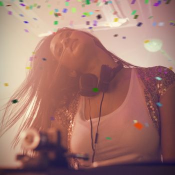Pretty female DJ dancing against flying colours