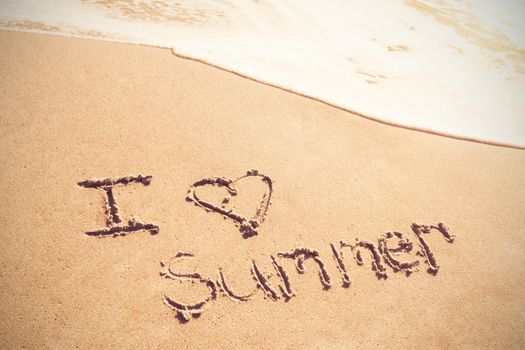 I love summer written on sand at beach