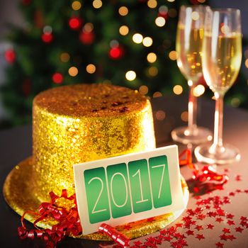  Digital composite of Happy new year card leaning on gold party hat