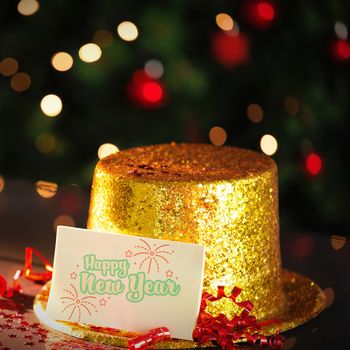  Digital composite of Happy new year card leaning on gold party hat