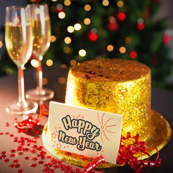  Digital composite of Happy new year card leaning on gold party hat