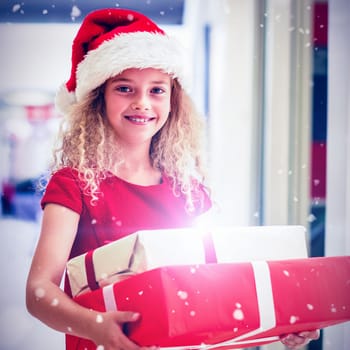 Portrait of girl in Christmas attire standing with gifts against snow falling