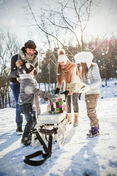 Happy family holding presents  against snow falling