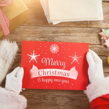 Santa claus holding a red placard against christmas card