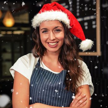 Portrait of barista wearing santa hat against snow falling