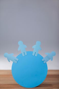 Conceptual image of blue and paper cut-out people on the circle