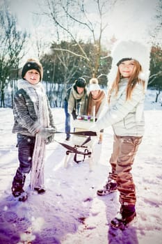 Family playing with sled against snow falling