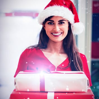 Portrait of woman in Christmas attire standing with Christmas gifts against snow falling