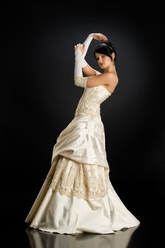 Young beautiful woman in a wedding dress on a studio background