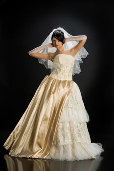 Young beautiful woman in a wedding dress on a studio background