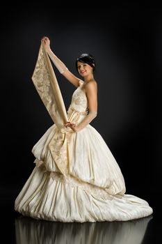 Young beautiful woman in a wedding dress on a studio background