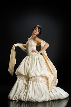 Young beautiful woman in a wedding dress on a studio background