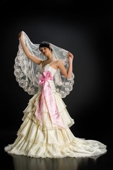 Young beautiful woman in a wedding dress on a studio background