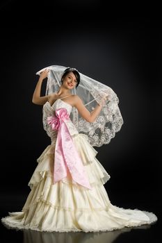 Young beautiful woman in a wedding dress on a studio background