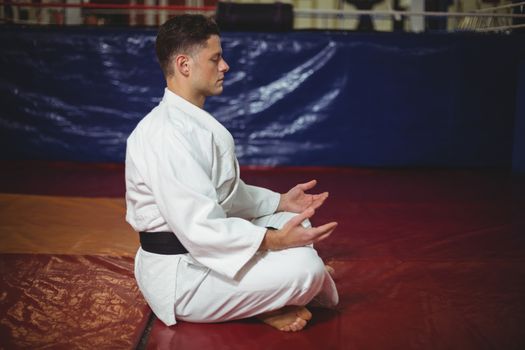 Karate player practicing yoga in fitness studio