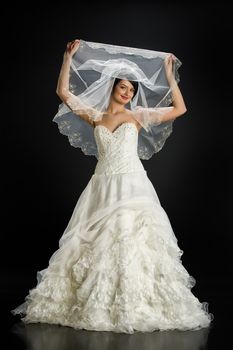 Young beautiful woman in a wedding dress on a studio background