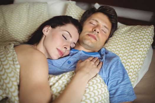 Romantic couple sleeping on bed in bedroom