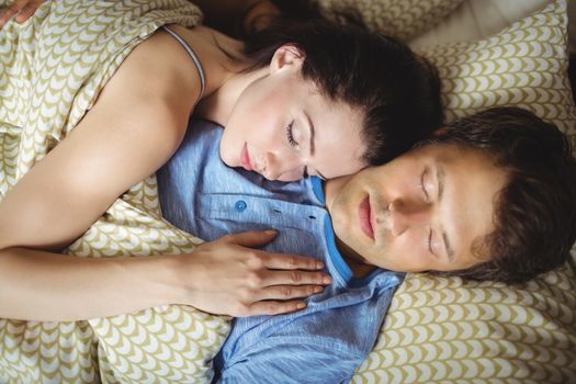 Romantic couple sleeping on bed in bedroom