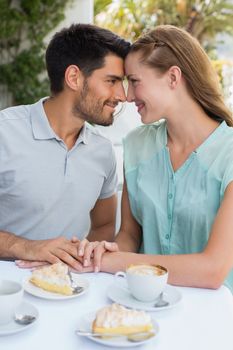 Romantic young couple looking at each other at the coffee shop