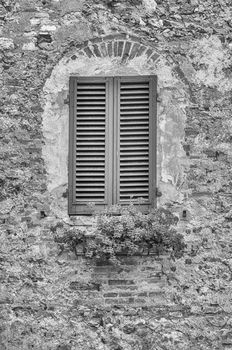 Scenic window in the medieval architecture of San Gimignano, iconic town in the province of Siena, and one of the most visited place in Tuscany, Italy