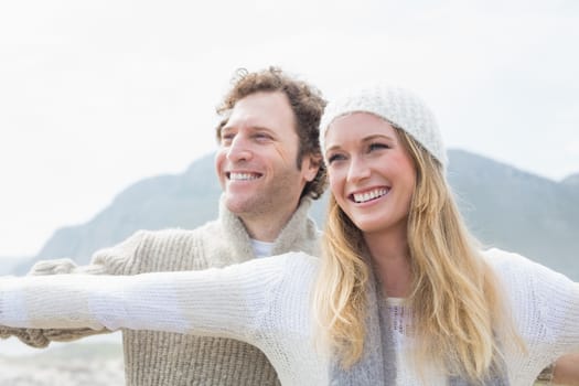 Closeup of a happy casual young woman and man stretching hands out outdoors