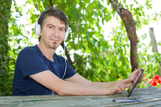 casual man working with a tablet pc, outdoor