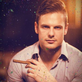 Portrait of man holding cigar and glass of whisky against flying colours