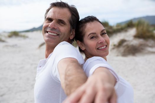 Portrait of romantic couple enjoying on beach during winter