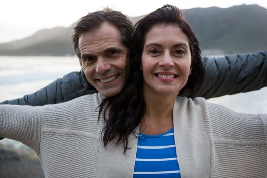 Portrait of romantic couple enjoying on beach during winter