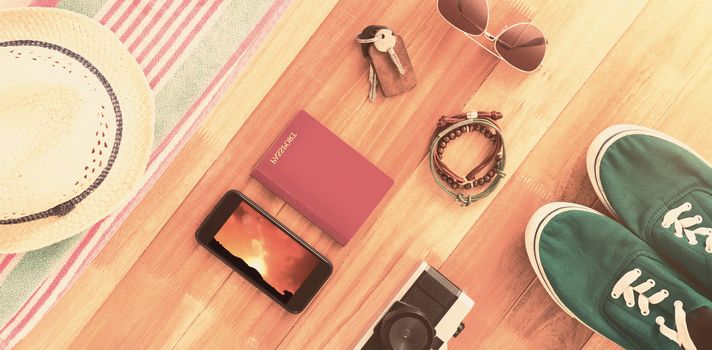 Accessories and travel items on wooden board against landscape with sunset