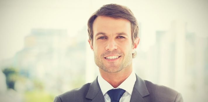 Portrait of a young businessman standing over blurred background outdoors