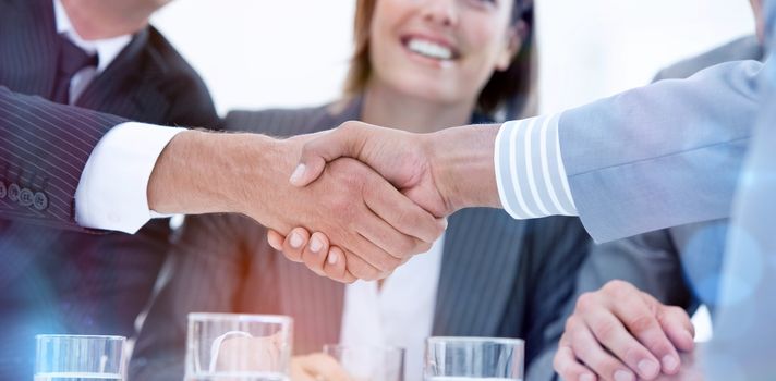 Smiling business people closing a deal against a white background