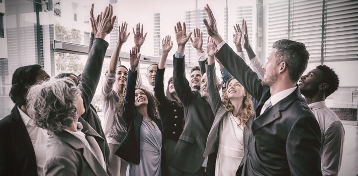Business people raising their arms during meeting in office