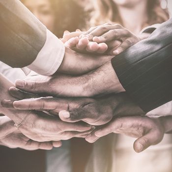Mid section of businesspeople with hand stacked in office