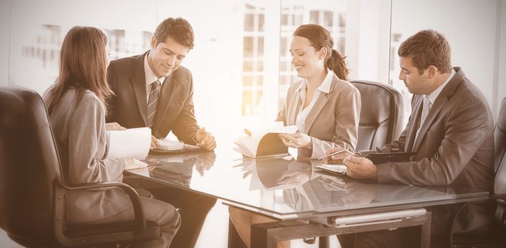 Four business people during a meeting sitting around a table 