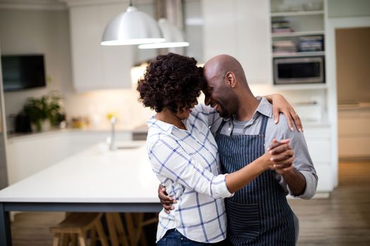 Romantic couple dancing in kitchen at home