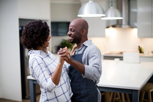 Romantic couple dancing in kitchen at home
