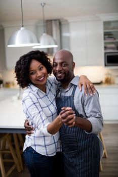 Portrait of romantic couple dancing in kitchen at home