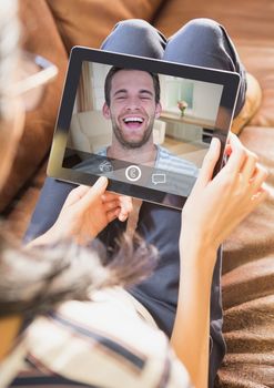 Woman having video calling on digital tablet at home