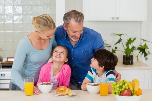 Happy family having breakfast in kitchen at home