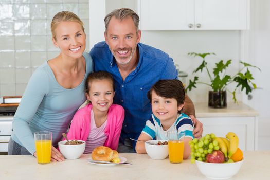 Portrait of happy family having breakfast in kitchen at home