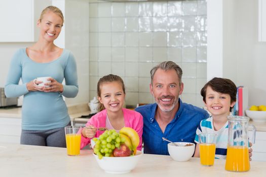 Portrait of happy family having breakfast in kitchen at home