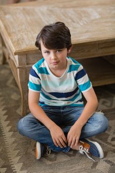 Portrait of boy sitting in living room at home
